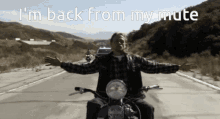 a man riding a motorcycle on a road with the words i 'm back from my mute above him