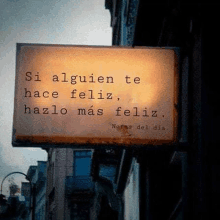 a sign that says `` si alguien te hace feliz , hazlo más feliz '' is hanging from a building .