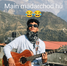 a man playing a guitar in front of a mountain with the words main madarchod hu below him