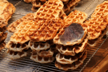 a bunch of waffles are stacked on a wire rack