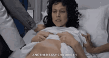 a pregnant woman is laying in a hospital bed with a doctor .