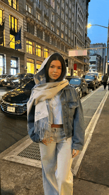 a woman wearing a denim jacket and a scarf with the letter n on it