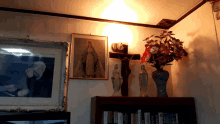 a corner of a room with a picture of jesus on the cross and a vase of flowers