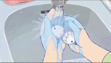 a person is washing something in a sink with blue gloves