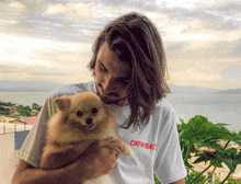 a man holding a small dog with a chewbacca t-shirt on