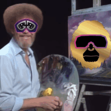 a man wearing goggles with the letter g on them stands in front of a painting