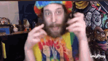 a man with a beard is wearing a tie dye hat and a shirt that says peace