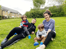 a family is sitting in the grass and the man is wearing a shirt that says ' reebok ' on the front