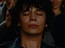 a woman is crying with her eyes closed