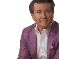a man in a purple suit and white shirt is sitting down