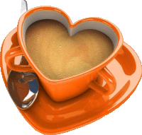 a heart shaped cup of coffee sits on a saucer with a spoon