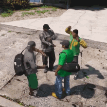 a group of men are standing on a sidewalk and one of them is wearing a green jacket with the letter m on it