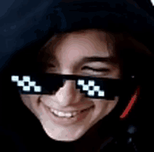 a close up of a person wearing sunglasses and a hoodie .