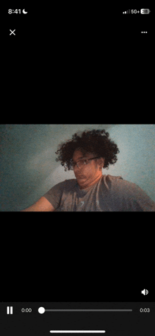 a video of a man with curly hair is being played on a cell phone