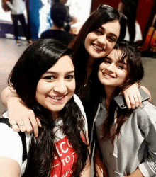 three girls posing for a picture with one wearing a shirt that says lc