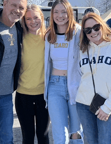 a woman wearing a idaho sweatshirt poses with her family