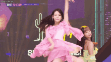 a woman in a pink dress is dancing on a stage with the show written on the bottom