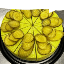 a cheesecake with pickles on top has been cut into pieces