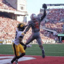 a football player is jumping in the air to catch a ball