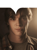 a close up of a young man 's face with a heart cut out of his hair