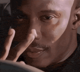 a close up of a man 's face with a finger on his nose