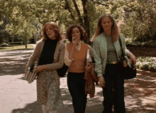 a woman smoking a cigarette while walking with two other women