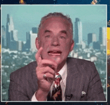 a man in a suit and tie with a ring on his finger is talking
