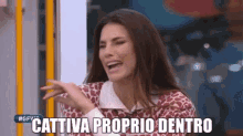 a woman is laughing with the words cattiva proprio dentro written below her