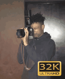 a man taking a picture with a 32k ultrahd sticker