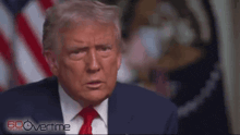 donald trump is wearing a suit and tie and a mask while talking on a video call .
