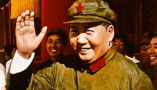 a man in a military uniform and hat is waving at a crowd of people .