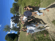 a group of people posing for a picture in a park with trees in the background