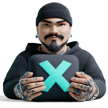 a man with a beard and tattoos is holding a box with a blue x on it