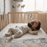 a baby is sleeping in a crib with a man 's head visible