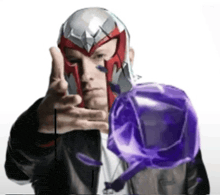 a man wearing a superhero helmet holds a purple object in his hand