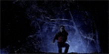 a blurry picture of a person standing in a dark room with trees in the background .