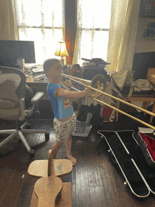 a little boy playing a trombone in a room