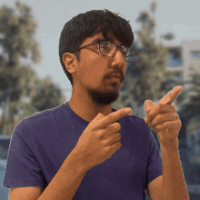 a man wearing glasses and a blue shirt is pointing