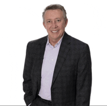 a man wearing a suit and a white shirt is smiling for the camera