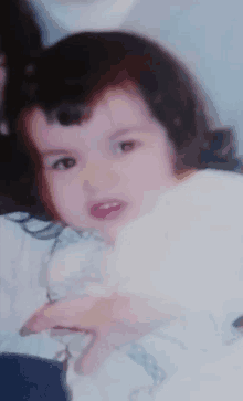 a close up of a little girl 's face with a white background