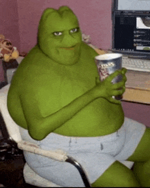 a fat green frog is sitting in a chair holding a cup of popcorn