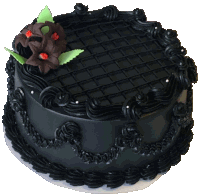 a round cake with black frosting and a chocolate flower on top