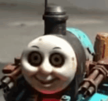 a close up of a thomas the tank engine toy train with a big smile on its face .