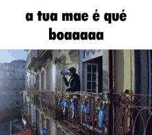 a man standing on a balcony holding a megaphone with the words a tua mae e que boaaaa