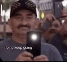 a man with a mustache is taking a picture of himself with his cell phone .