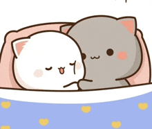 a couple of cats laying on top of each other on a bed with hearts on it .