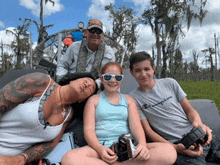 a man wearing a champion t-shirt sits with his family