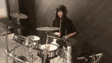 a woman wearing headphones is playing drums