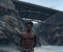 a shirtless man standing in front of a bridge