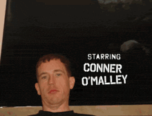 a man is standing in front of a sign that says starring conner omalley
